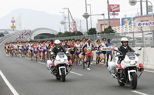 スタート直後から激しいトップ争いをする国内外の有力選手（丸亀市原田町の国道11号跨線橋付近）